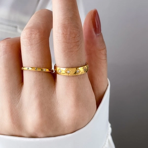 Close-up of gold plated ring set featuring starburst engraving and cz stones on model