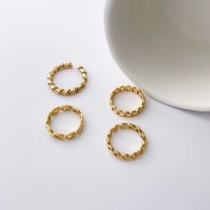 Lot de quatre bagues dorées en acier inoxydable avec motifs chaîne et spirale tordue