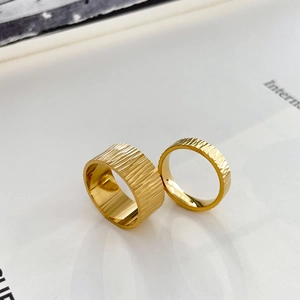 Detail of 18K gold titanium steel rings with textured bark and gear tire pattern