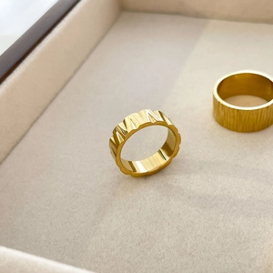 Detail of 18K gold titanium steel rings with gear texture and bark wrinkle patterns