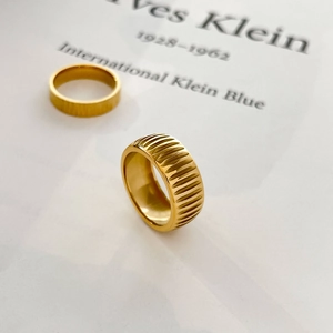 Macro detail of gold titanium steel ring set with textured bark and groove patterns
