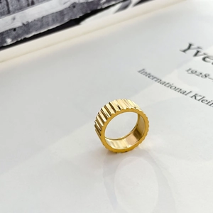Detailed close-up of a 18K gold-plated wide gear ring with textured industrial fluted patterns
