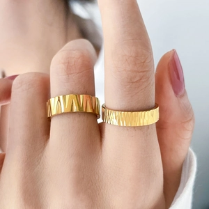 Detail of 18K gold titanium rings featuring gear sawtooth and bark texture designs
