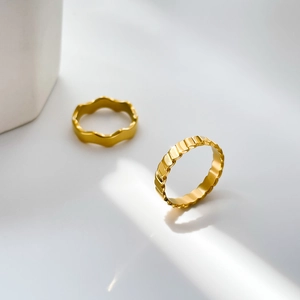 Close-up of 18K gold plated rings with textured wave and gear fish scale patterns