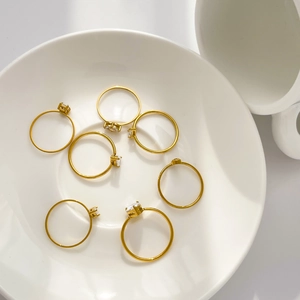 Vue détaillée de bagues minimalistes plaquées or 18K avec zircon sur une coupelle