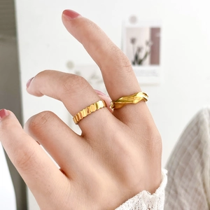 Detailed view of gold 18K plated stainless steel rings with wave and pleated textures