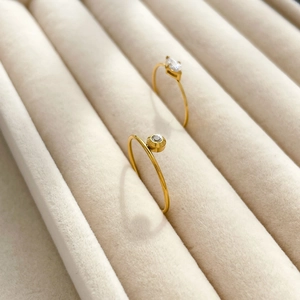 Détail de deux bagues minimalistes plaquées or 18 carats avec zircons sur plateau