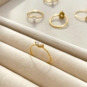 Gros plan d'une bague en acier titane doré avec zircon taille marquise sur velours