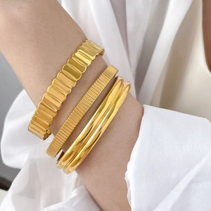 Three-piece gold titanium steel gear cuff bracelet set with textured and smooth finishes