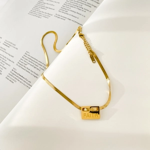 Detail of K18 gold herringbone chain with a rectangular Faith letter engraved pendant