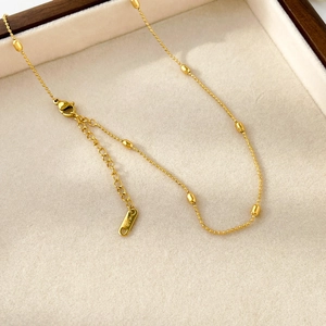 Detail of 18K gold beaded chain necklace with lobster clasp and K18 hallmark stamp