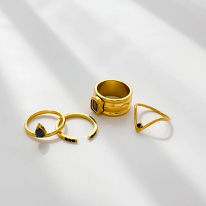 Set of four gold stainless steel rings with black zircon stones and water drop design