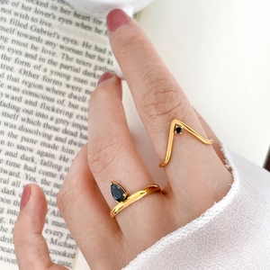 Detail of gold water-drop black zircon and V-shaped ring set on model hand