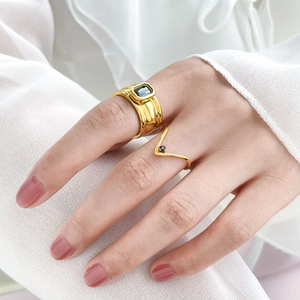 Detail of stacked gold rings with wide black zircon stone and minimalist V-shaped band