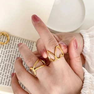 Bagues dorées minimalistes avec motifs cœur évidé et dentelle sur la main