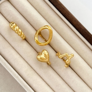 Set of four gold-plated rings with twisted, oval, heart and wavy lava liquid designs