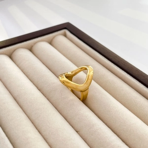 Close-up of a gold abstract hollow triangle ring in a luxury velvet jewelry box