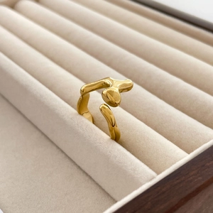 Detailed close-up of gold lava fluid ring displayed in a beige velvet jewelry box