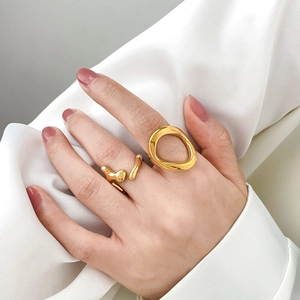 Minimalist gold-plated irregular hollow and twisted rings on a white silk background