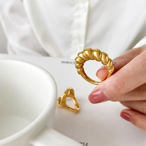 Macro view of golden croissant twist ring with polished spiral texture on model