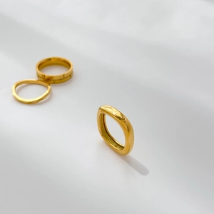Detailed close-up of a minimalist 18k gold plated ring set with geometric textures