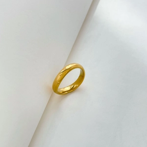 Close-up of a 18k gold-plated titanium steel ring with a polished curved surface