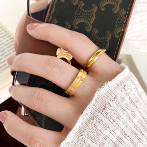 Macro detail of geometric grid and smooth surface rings in 18k gold plated titanium steel