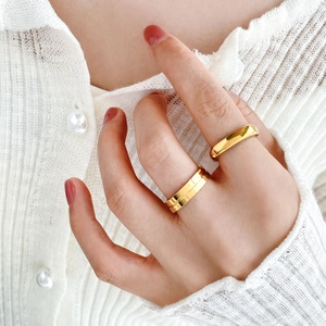 Close-up of polished 18k gold plated ring with vertical grooves on a model's finger