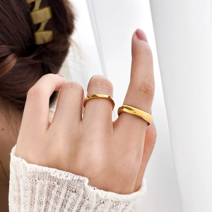 Stacked 18k gold-plated titanium rings featuring geometric faceted and smooth domed designs