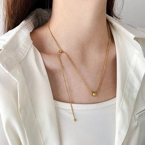 Gros plan d'un collier en maille serpent dorée ajustable avec perle sur un mannequin
