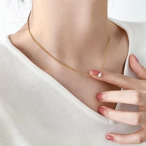 Gros plan d'un collier avec pendentif en zircone poire sur une fine chaîne dorée