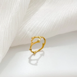 Macro detail of golden branch-shaped ring with wave texture and organic branch design
