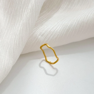 Detail shot of a minimalist gold wave ring with organic branch-like flowing lines