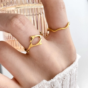 Detail of minimalist wave and branch style rings in polished gold finish on a hand