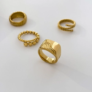 Detailed view of stacked 18K gold plated rings featuring twisted and wavy textures