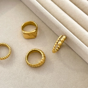 Detailed view of 18K gold plated stackable rings with twisted, wave and beaded textures