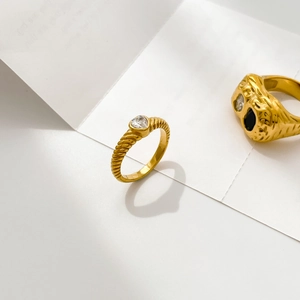 Macro detail of gold-plated rings with twisted texture and heart-shaped zircon stones