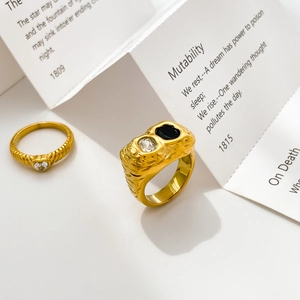 Macro shot of 18K gold plated rings with lava texture, black zircon, and heart crystal