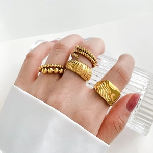 Detail of 18K gold plated ring set featuring croissant texture and beaded twist designs