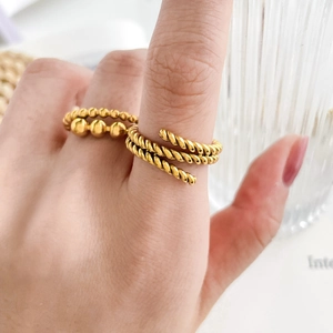 Close-up of gold beaded and multi-layer twisted rope rings on model hand