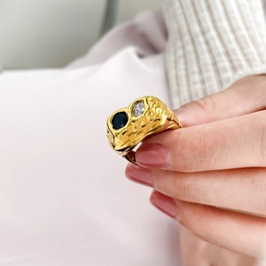 Detail of 18K gold ring with irregular lava texture and black and white zircons