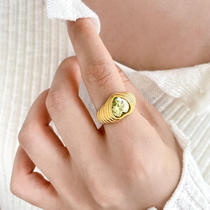 Macro detail of 18K gold plated ring featuring a heart-shaped zircon on textured band