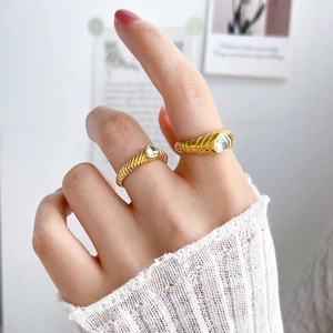 Detail of 18K gold plated spiral rings with teardrop zircon on a model's hand