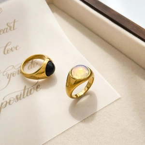 Close-up of gold plated rings with black onyx and opal stones on a display tray
