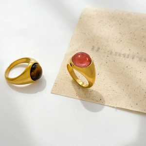 Detail of vintage 18K gold plated rings featuring round tiger eye and pink opal gemstones