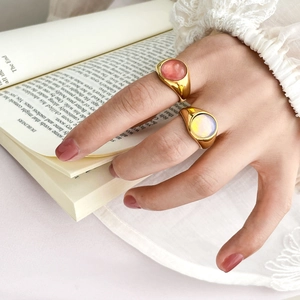 Detail of vintage 18K gold plated oval gemstone rings on a classic book page