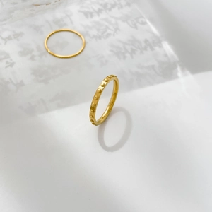 Macro detail of golden beaded ring band with polished finish on zen calligraphy paper