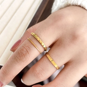 Three-piece gold ring set featuring twist rope, dotted studs, and sunburst textures