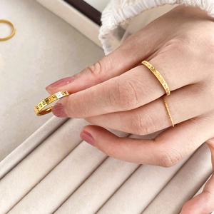 Three-piece gold plated Chinese character engraved rings on cream velvet jewelry display