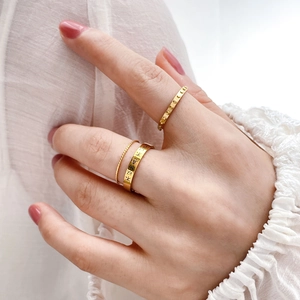 Three-piece gold ring set featuring Chinese character engraving and textured band designs